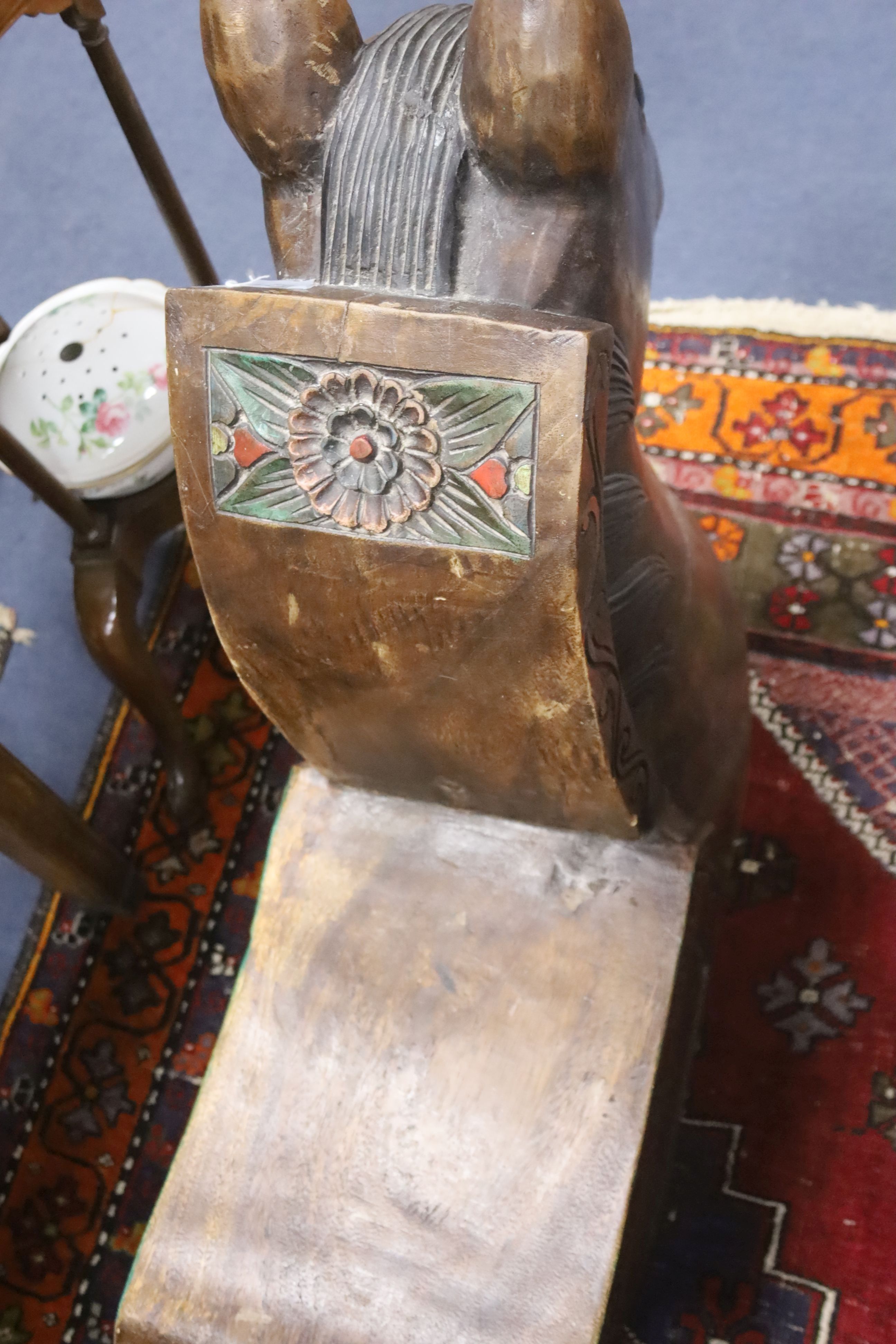 A large decorative carved hardwood horse shaped stool, 60cm. long. 26cm. wide. 72cm. high.